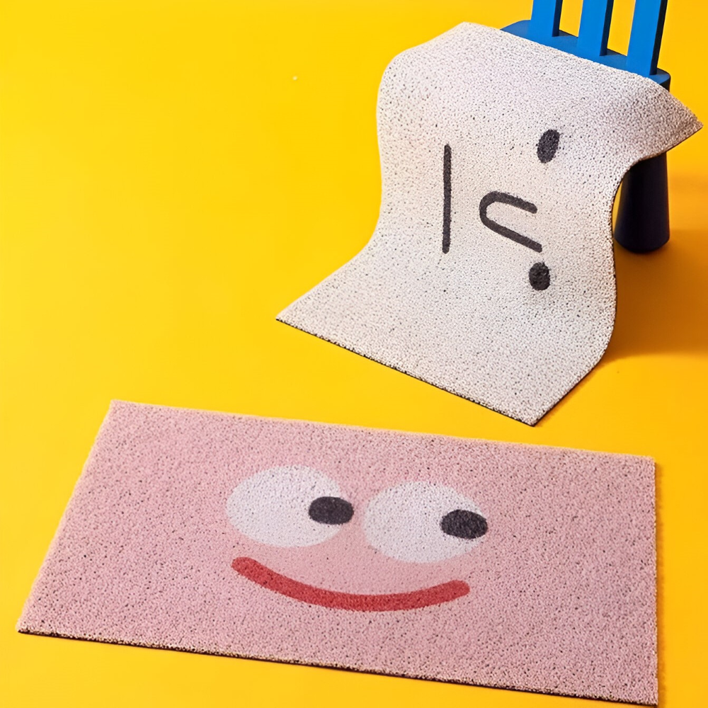 Two doormats with cartoon face designs on a yellow background