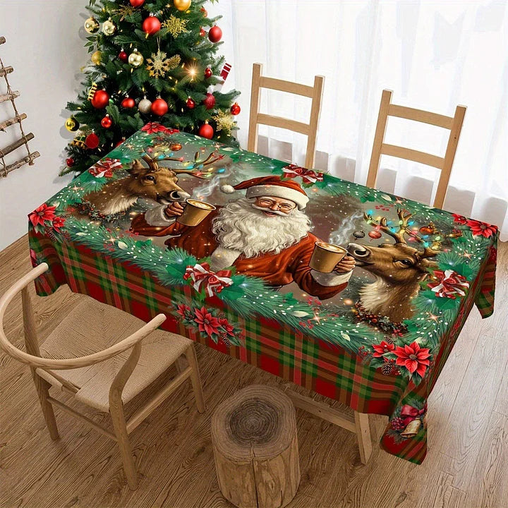 Dining table with a Christmas-themed tablecloth featuring Santa Claus and reindeer, next to a decorated Christmas tree.