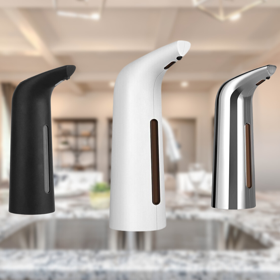 Three soap dispensers in black, white, and silver on a blurred kitchen background