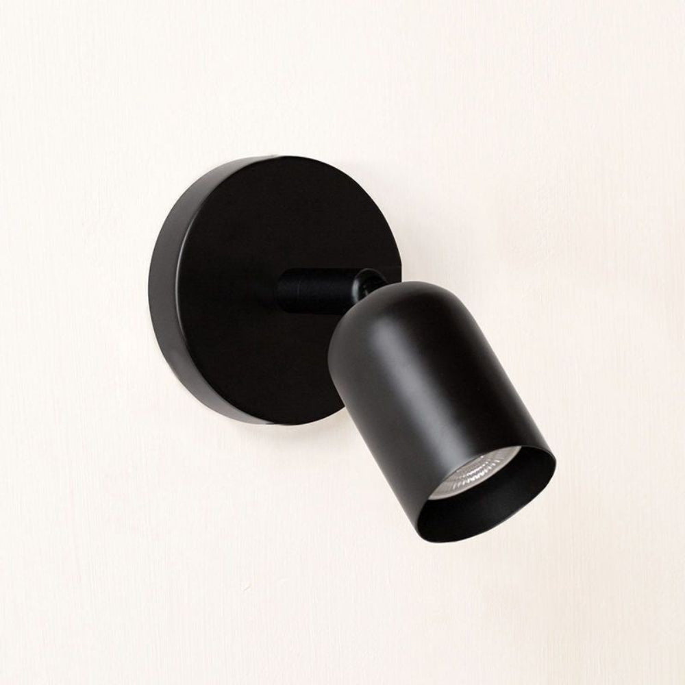 Black wall-mounted light fixture on a white background