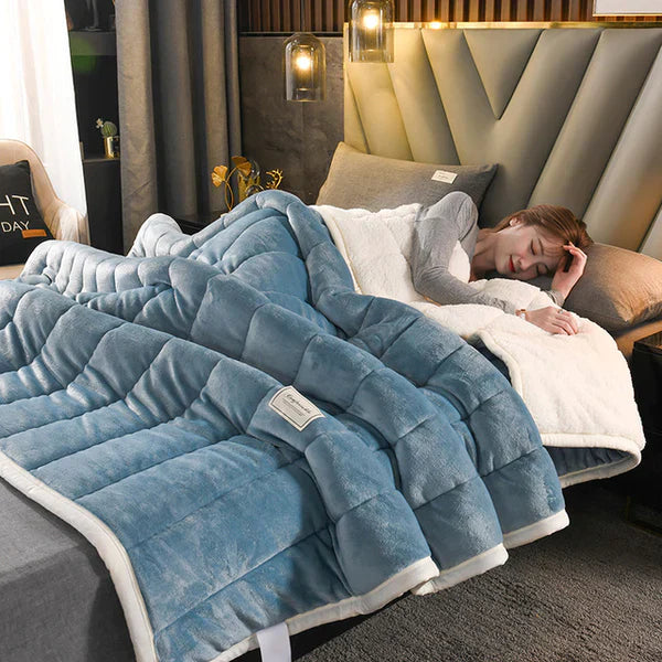 Person lying on a bed with a blue weighted blanket