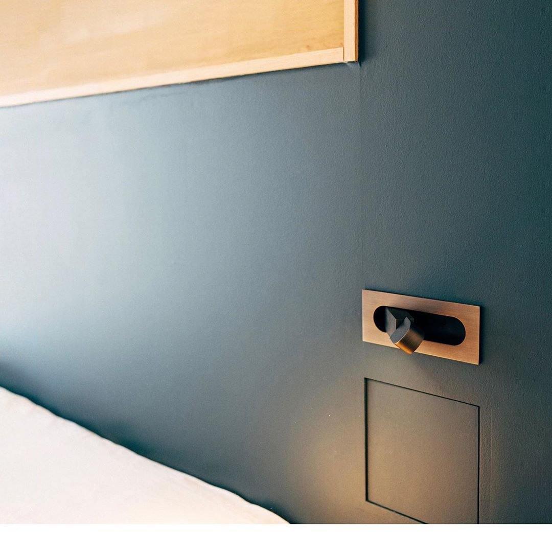 Brass wall-mounted light fixture on a blue wall