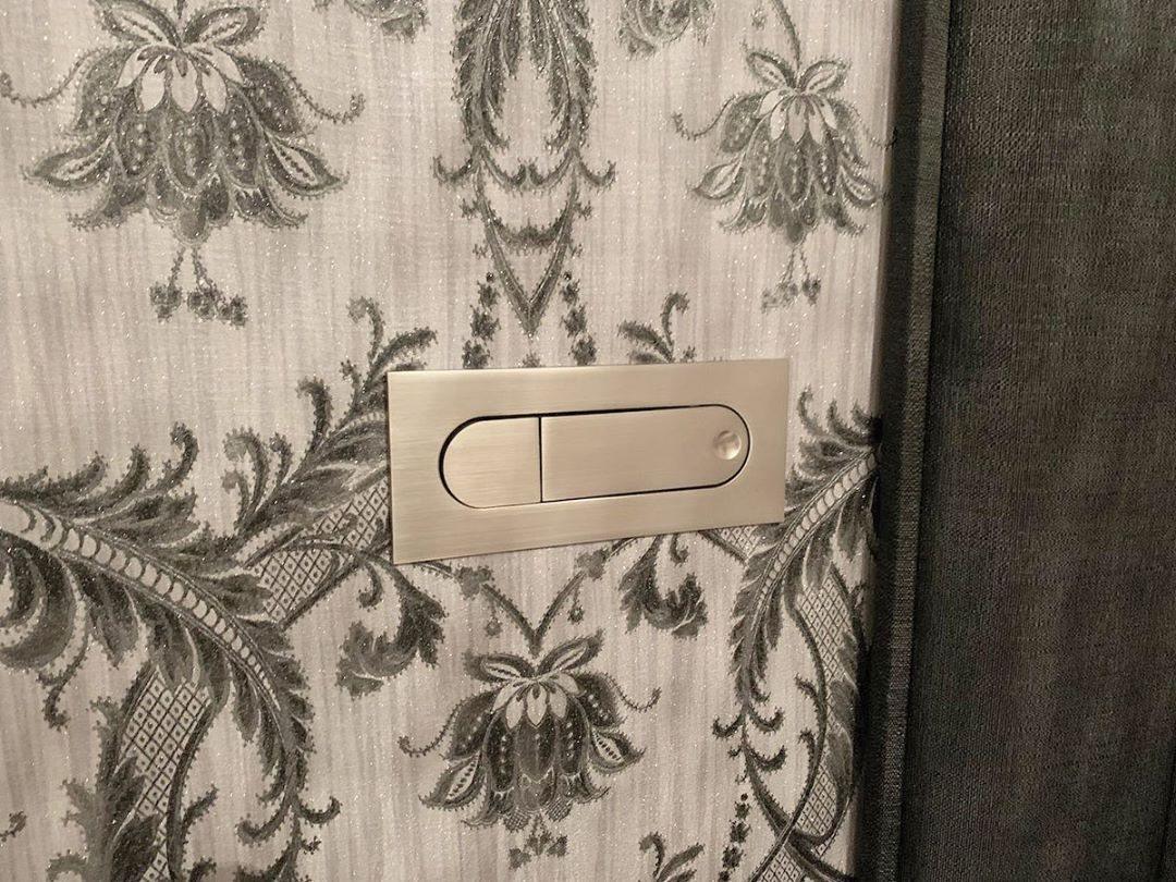 Decorative wall panel with floral pattern and metallic light switch.