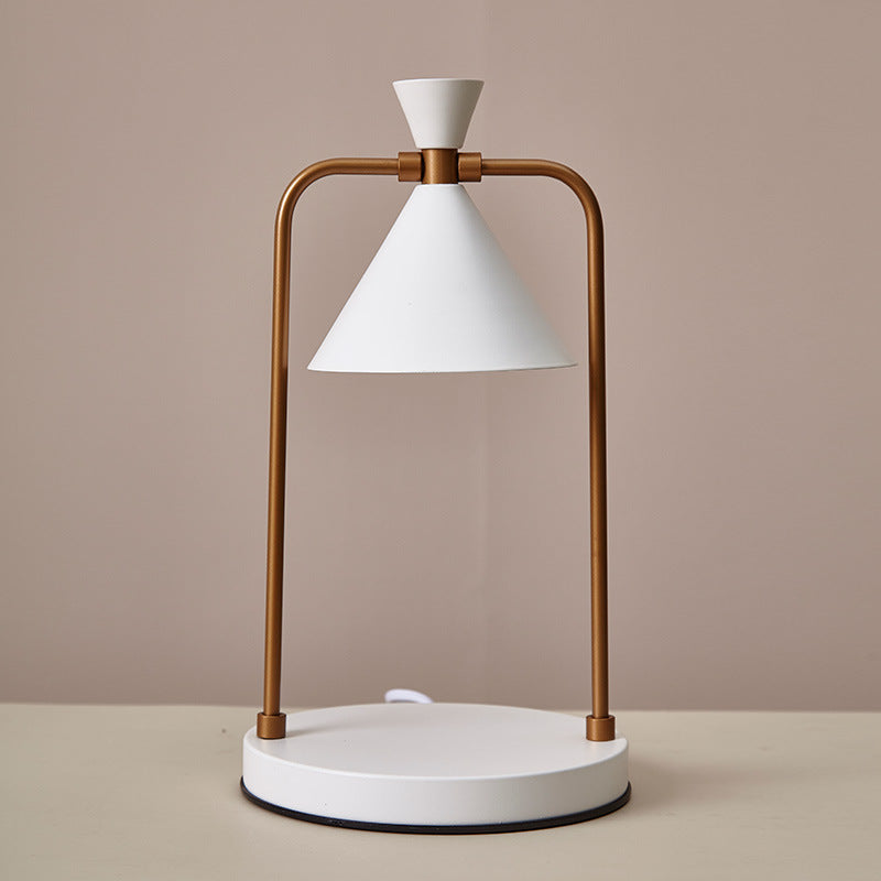 Table lamp with white shade and bronze metal frame on a beige background