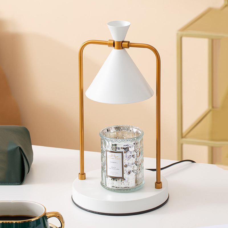 Table lamp with white shade and gold base on a white surface with a beige wall background