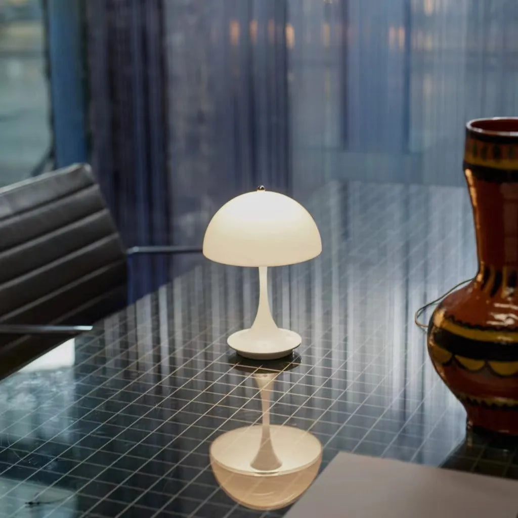 Small table lamp on a reflective surface with a blurred background