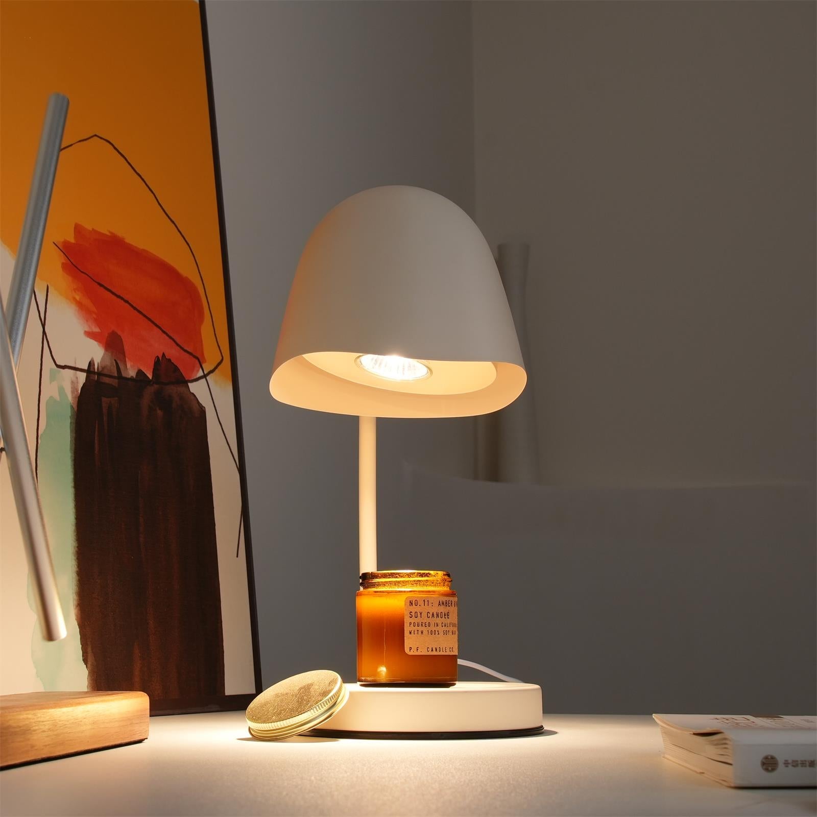 Table lamp with a candle on a surface, with a blurred background