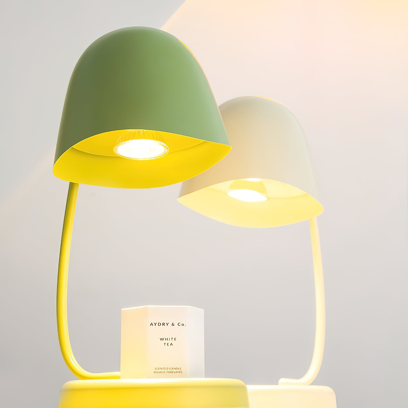Two colorful lamps with a candle on a gray background
