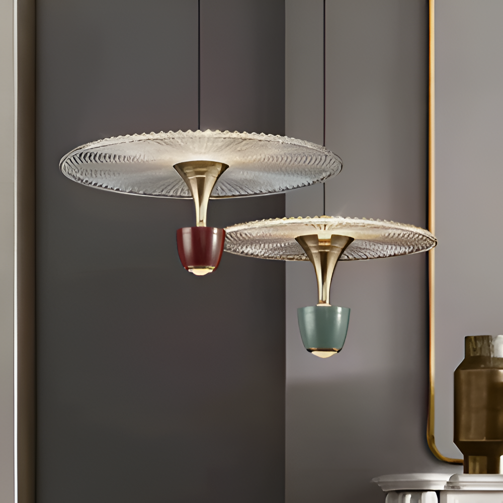 Modern pendant lights with glass shades and metallic bases against a gray wall.