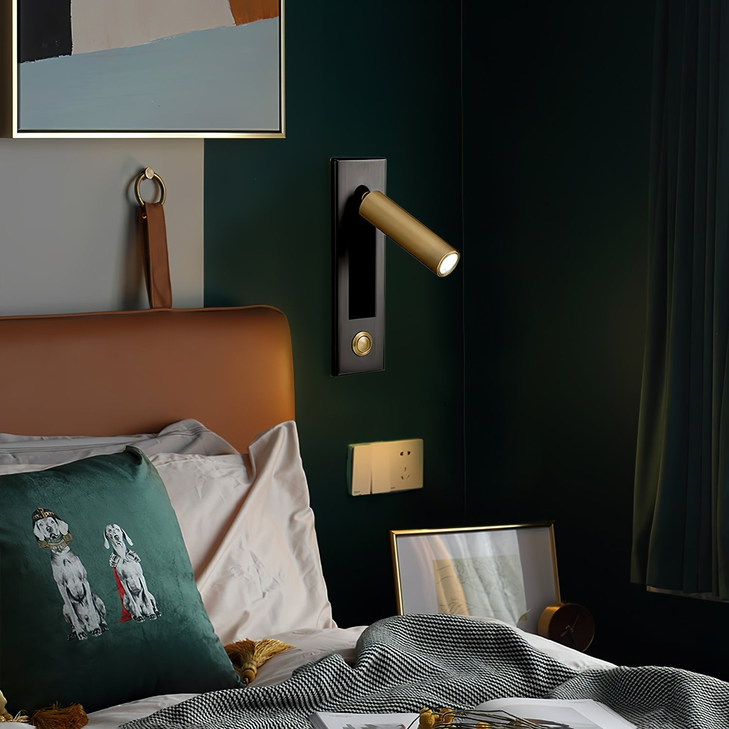 Bedroom interior with a brown headboard, green pillow with dog design, and wall-mounted light fixture.