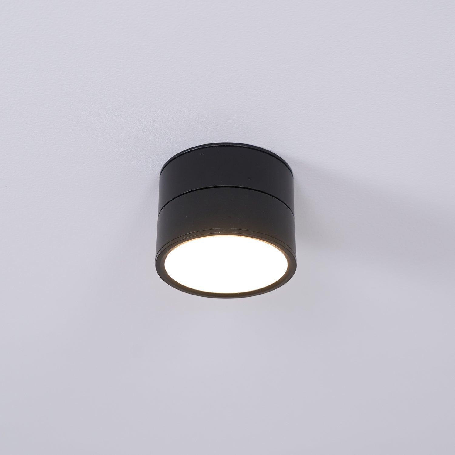 Black cylindrical ceiling light fixture on a white background