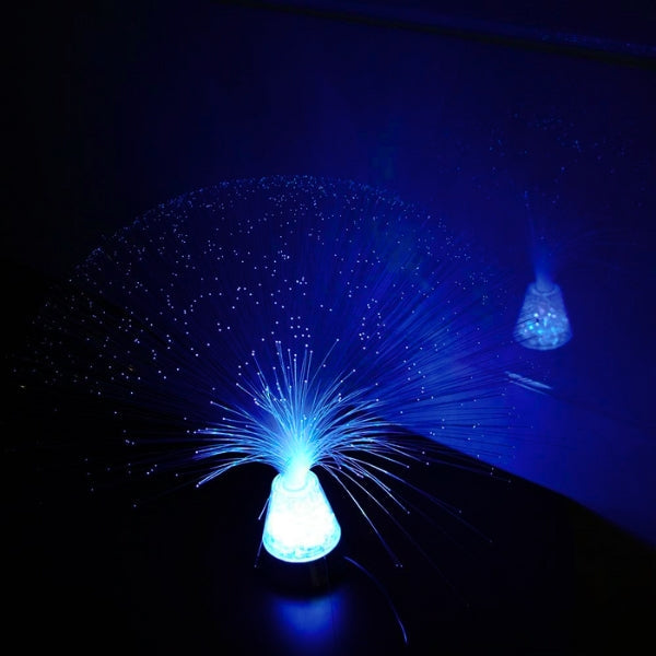 Blue fiber optic light bulb emitting a starry effect on a dark background