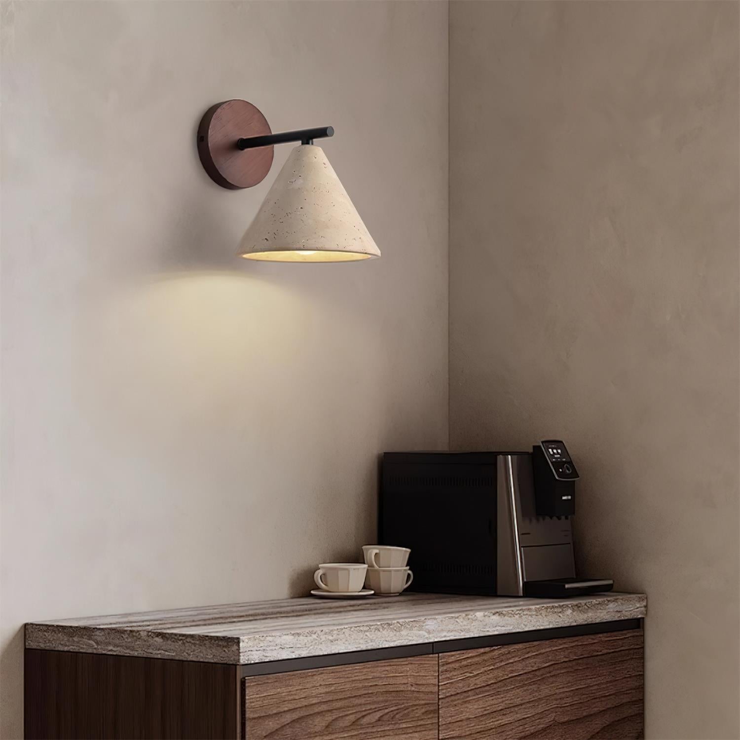Modern wall lamp above a wooden console table with a coffee machine and cups.