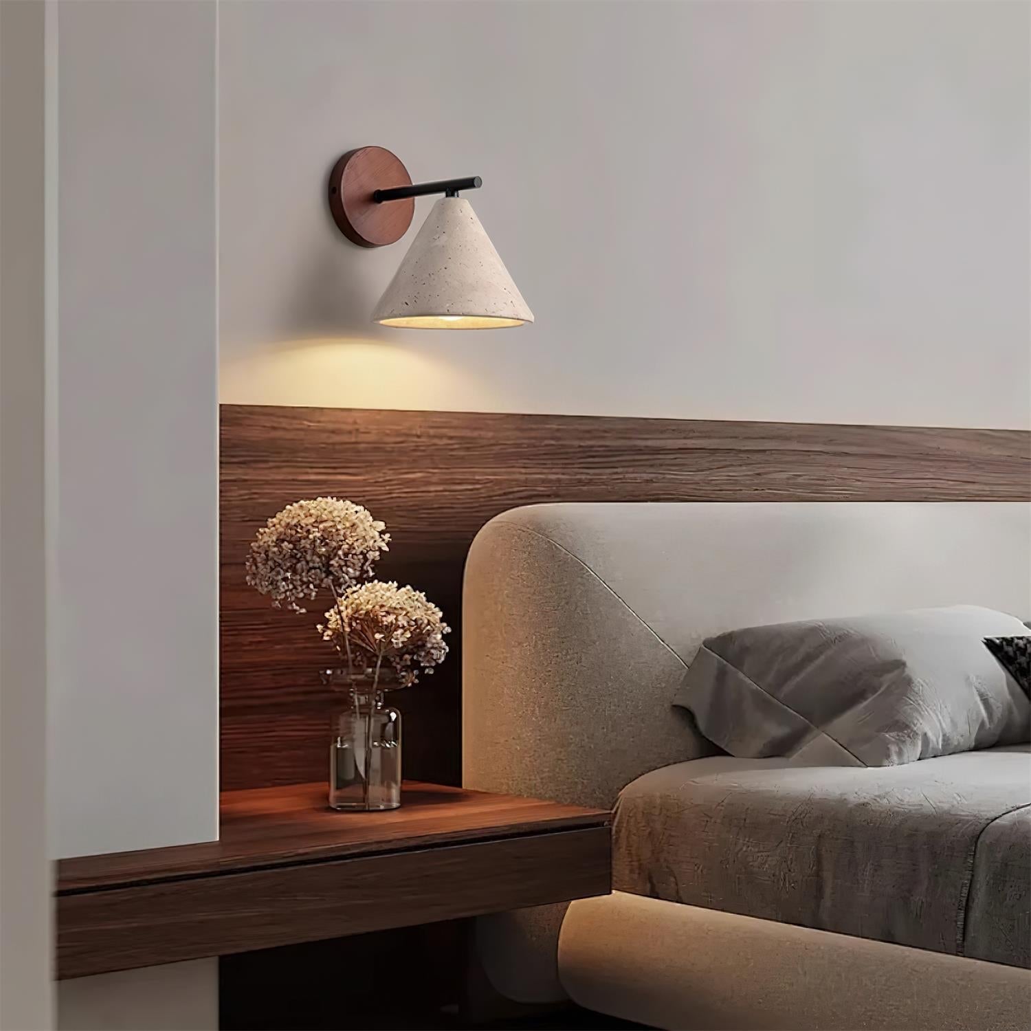 Modern bedroom with a wooden headboard, wall lamp, and decorative vase.