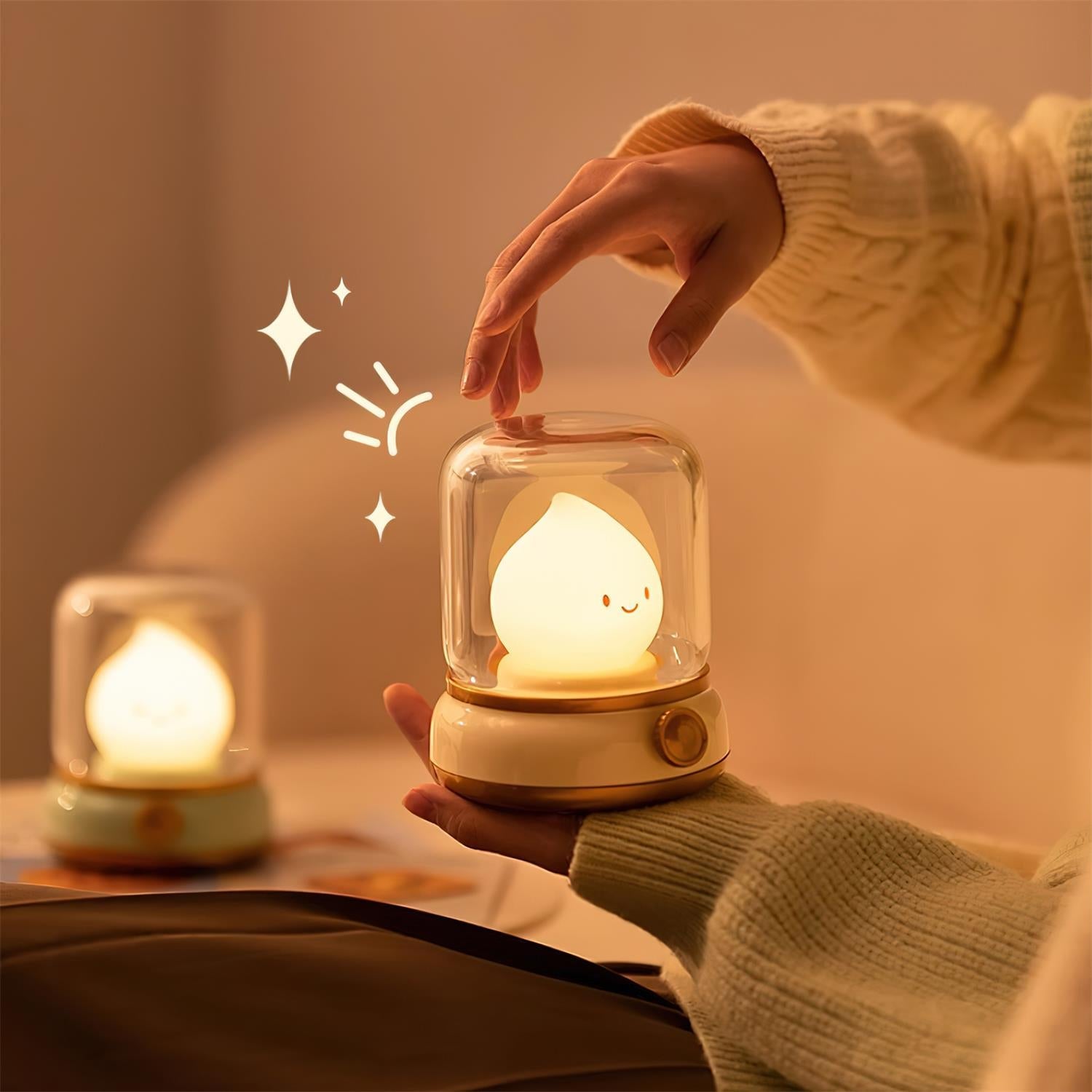 Person holding a small glass night light with a warm glow, surrounded by soft lighting and a cozy atmosphere.