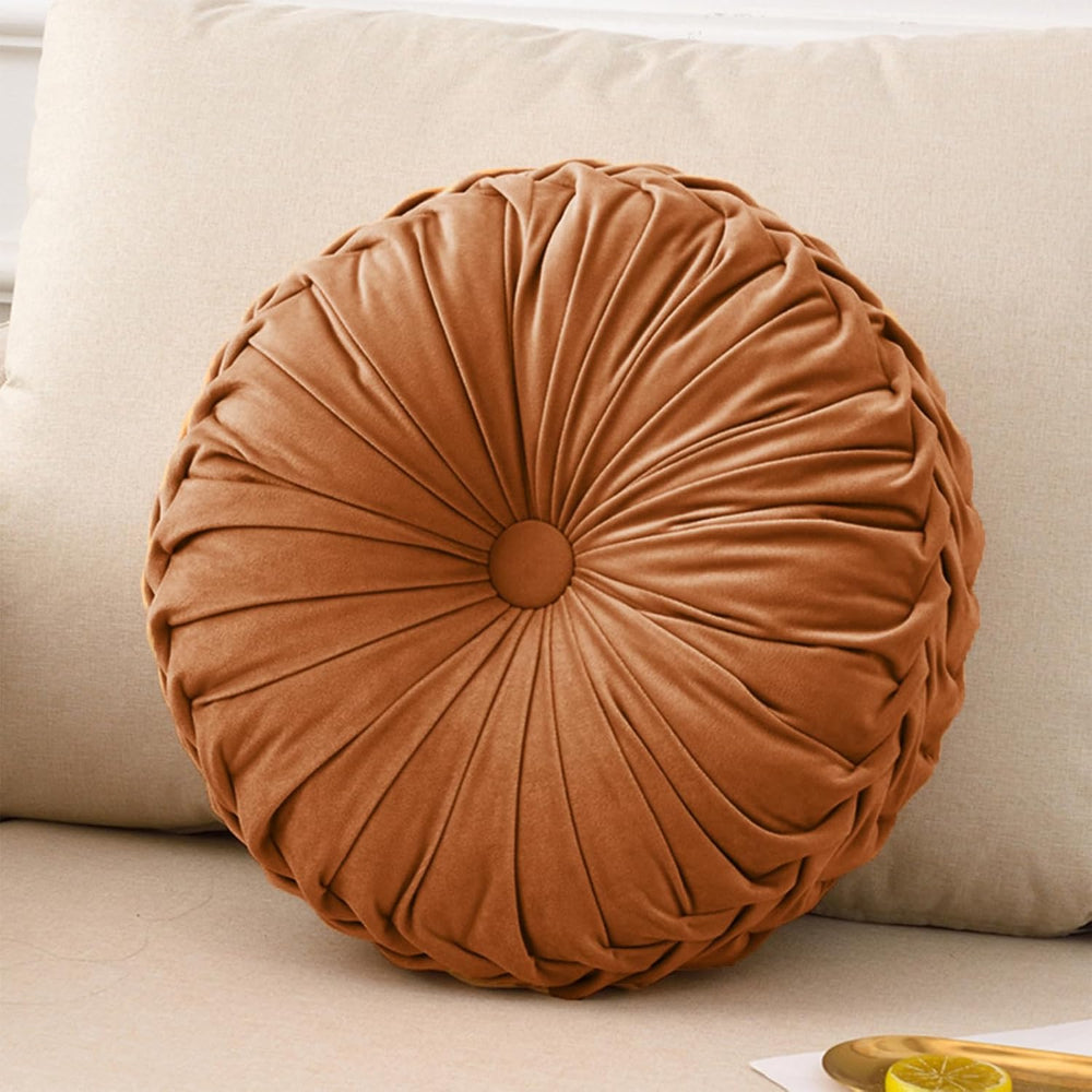 Round brown pillow on a beige sofa