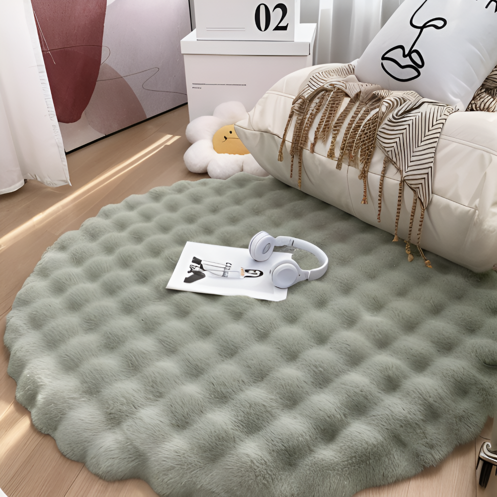 Round green rug on a wooden floor with a pillow and headphones on top
