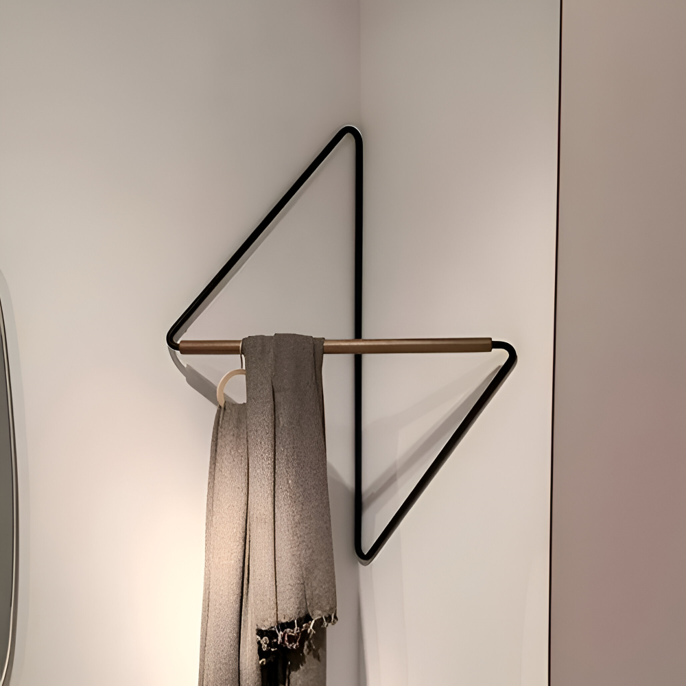 Modern wall-mounted coat rack with a scarf hanging on it against a neutral background