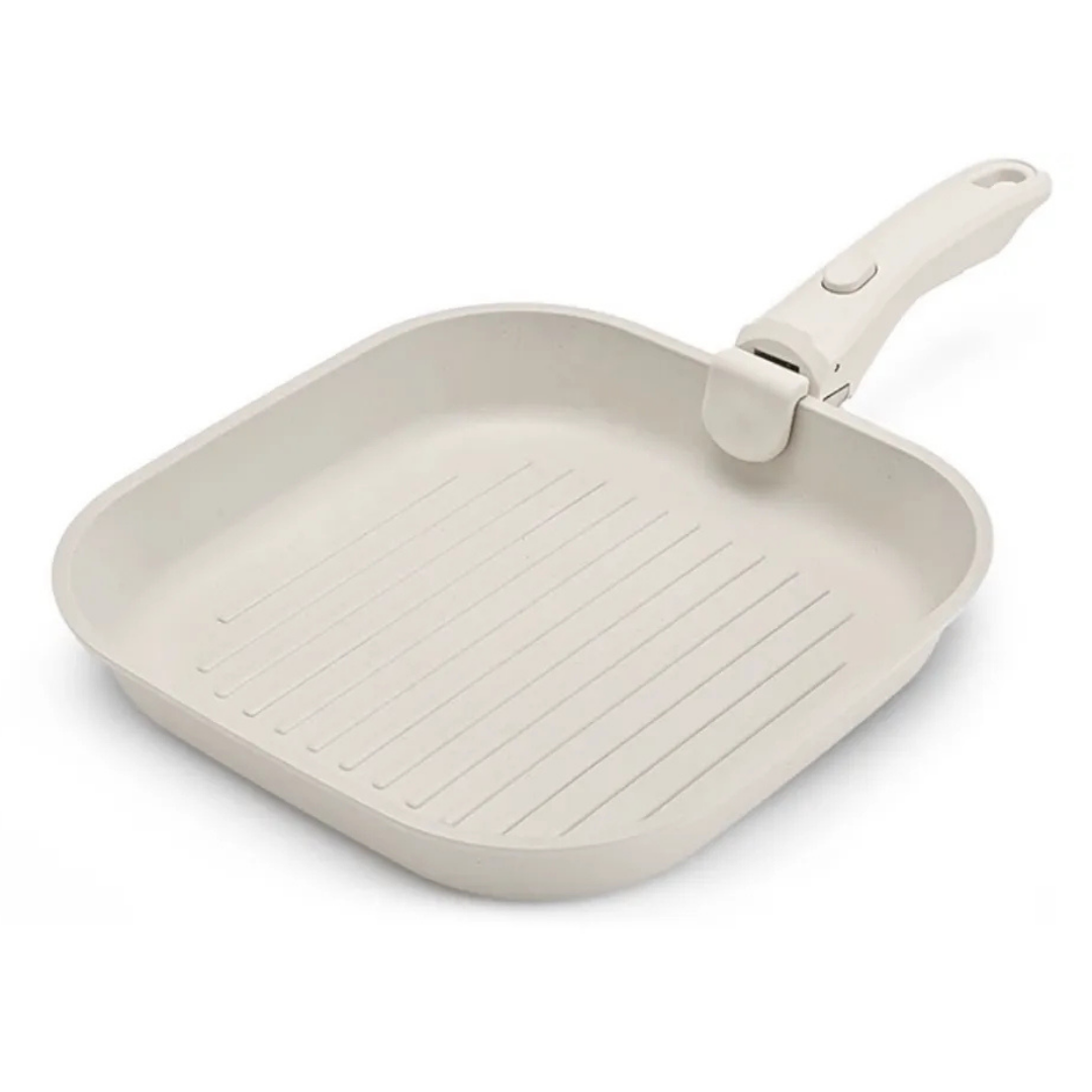Beige square grill pan with handle on a white background