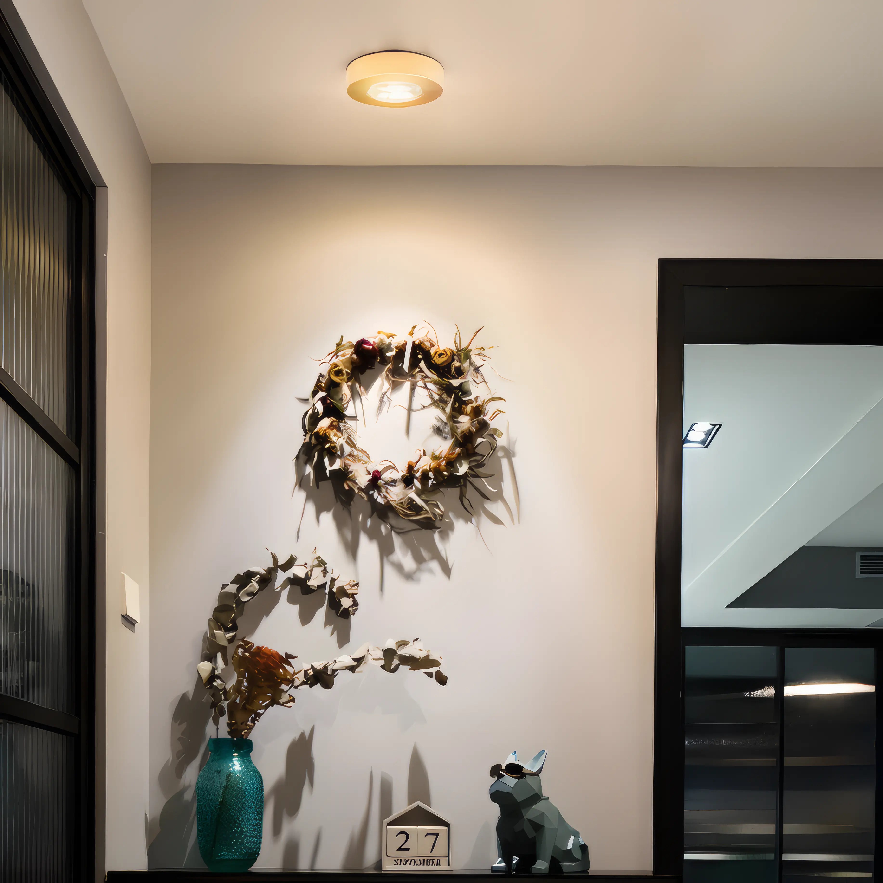 Decorative wreath on a wall with a small dog figurine and number '27' sign below.