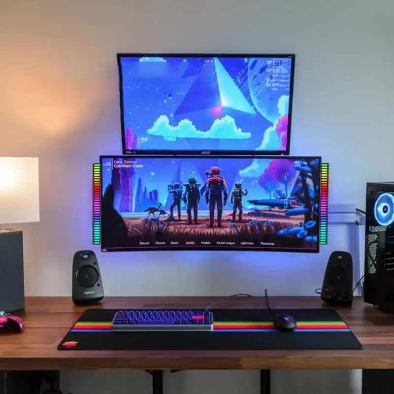 Gaming setup with dual monitors, keyboard, mouse, and RGB lighting on a desk.