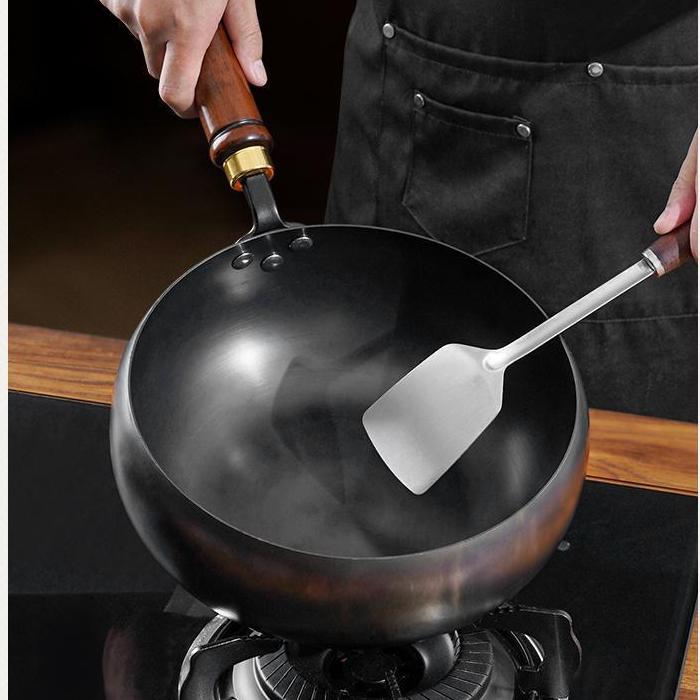 Person using a wok with a spatula on a stove