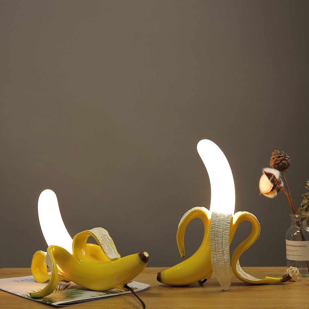 Banana-shaped lamp on a wooden surface with a dark gray background