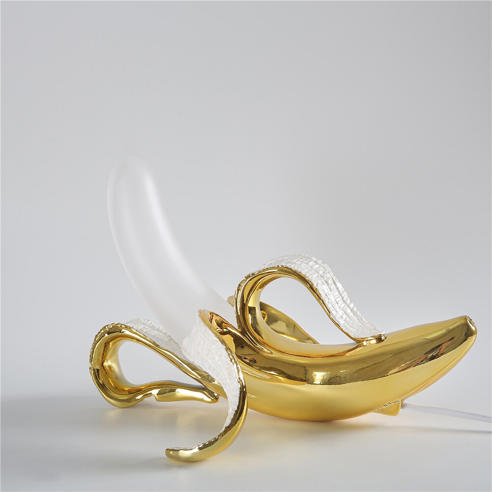 Gold banana-shaped decorative item on a light gray background
