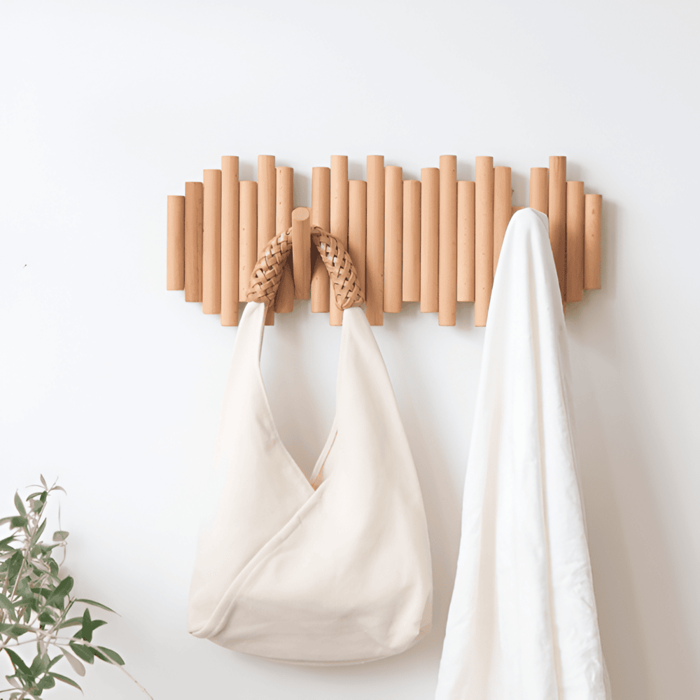 Wooden wall hook with two white bags hanging on a light background