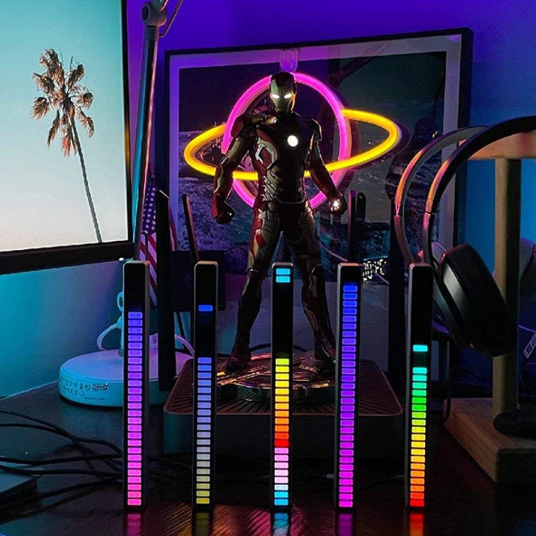 Gaming setup with Iron Man figure and colorful LED lights in a room.