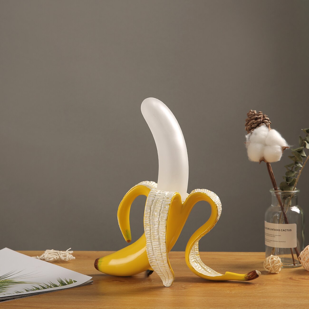 Decorative banana sculpture on a wooden surface with a gray background