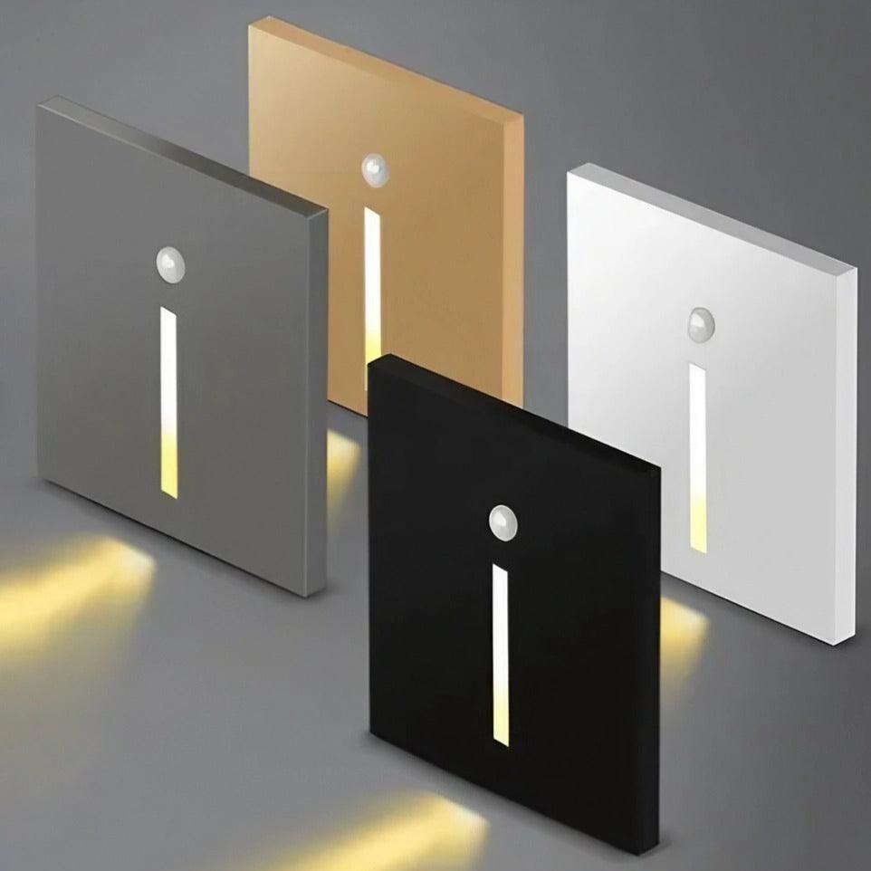 Four rectangular light switches in different colors on a gray background