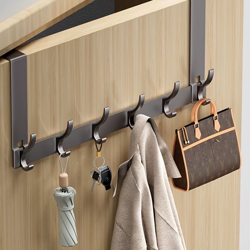 Wall-mounted hook rack with coat, umbrella, keys, and handbag on a wooden door.