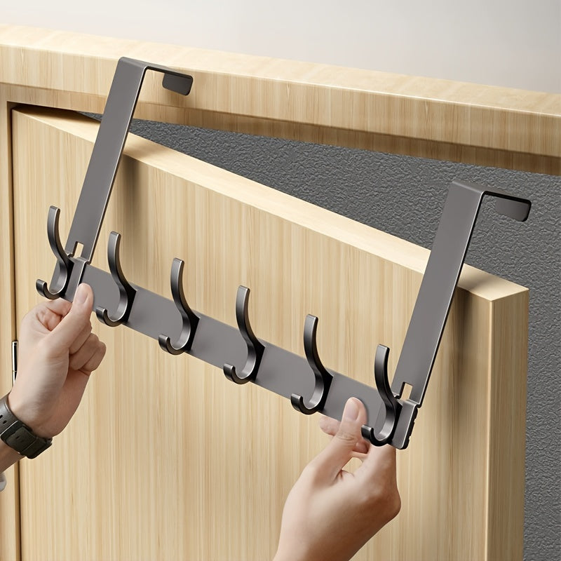Person installing a metal hook rack on a wooden door.