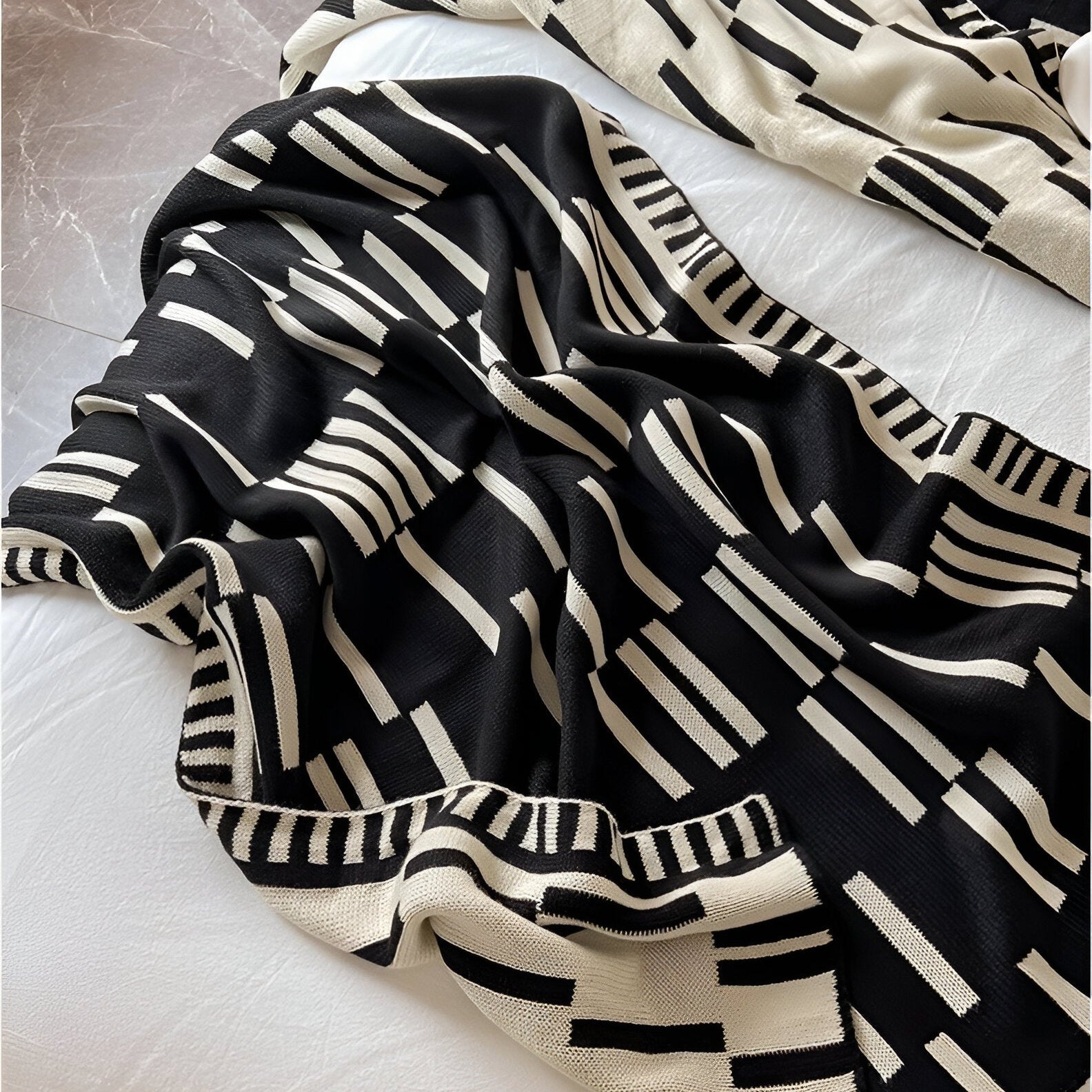 Black and white striped blanket on a textured surface