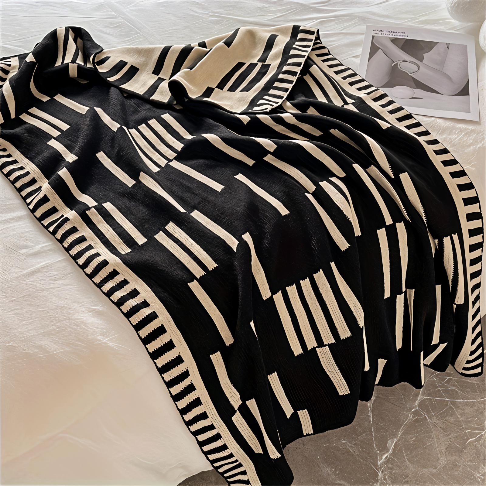 Black and beige patterned throw blanket on a bed
