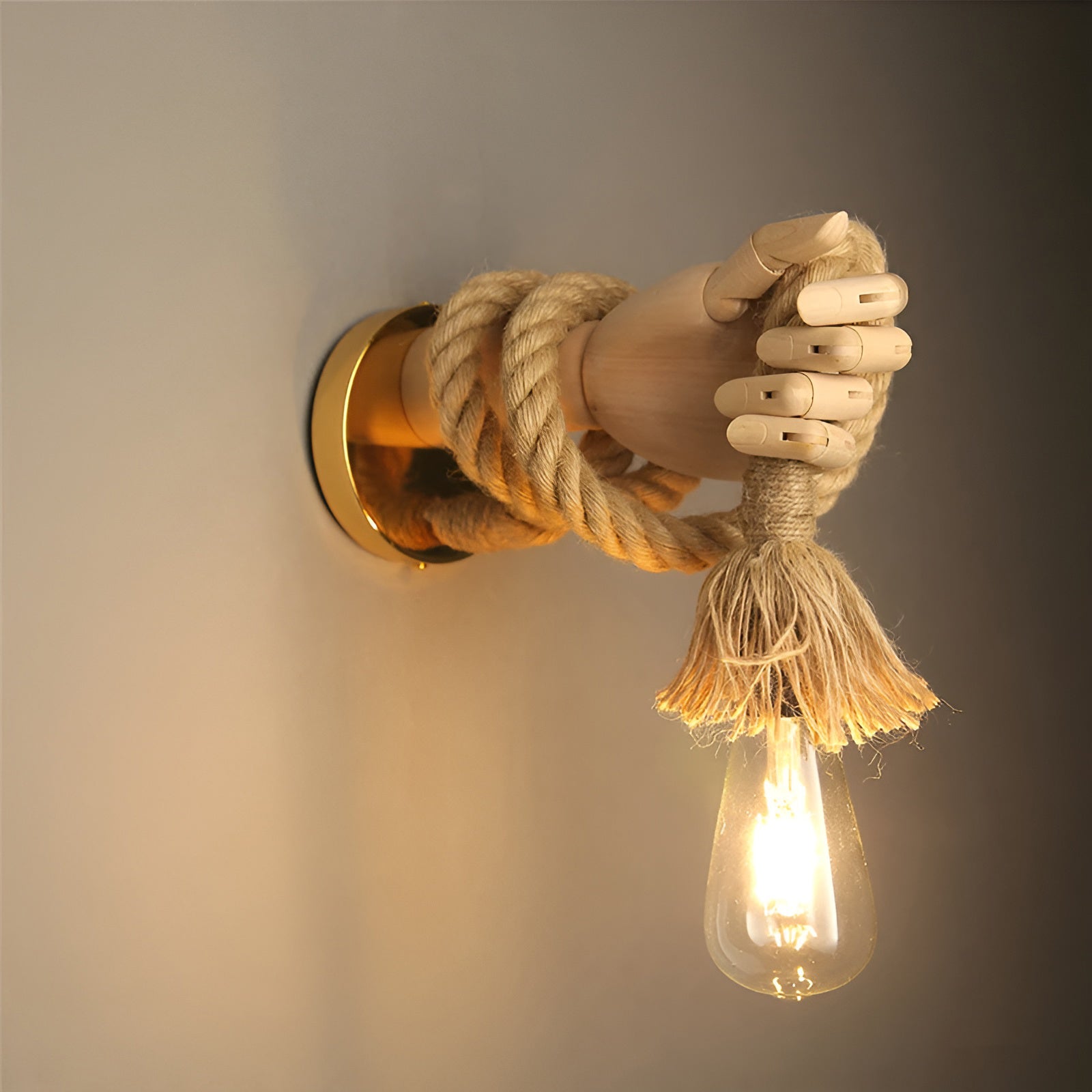Wall-mounted light fixture with a hand holding a rope and a lit bulb against a neutral background