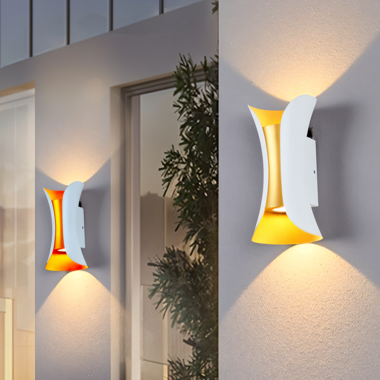 Modern wall lights on a building exterior with a plant in the background