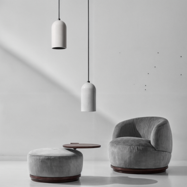 Modern gray chair and ottoman with a pendant light on a white background