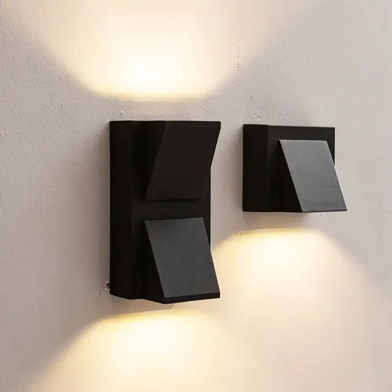 Two modern black wall lights on a white wall