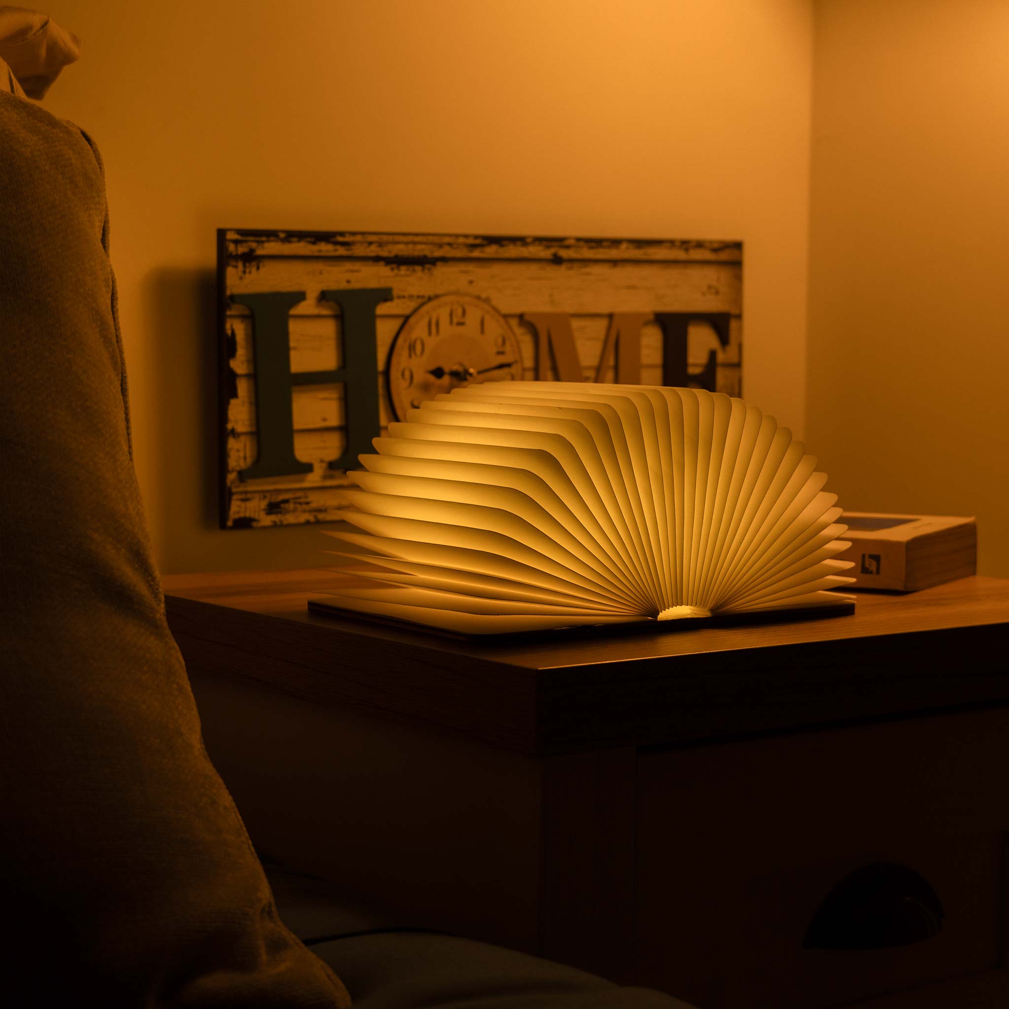 Book-shaped lamp on a bedside table with warm lighting