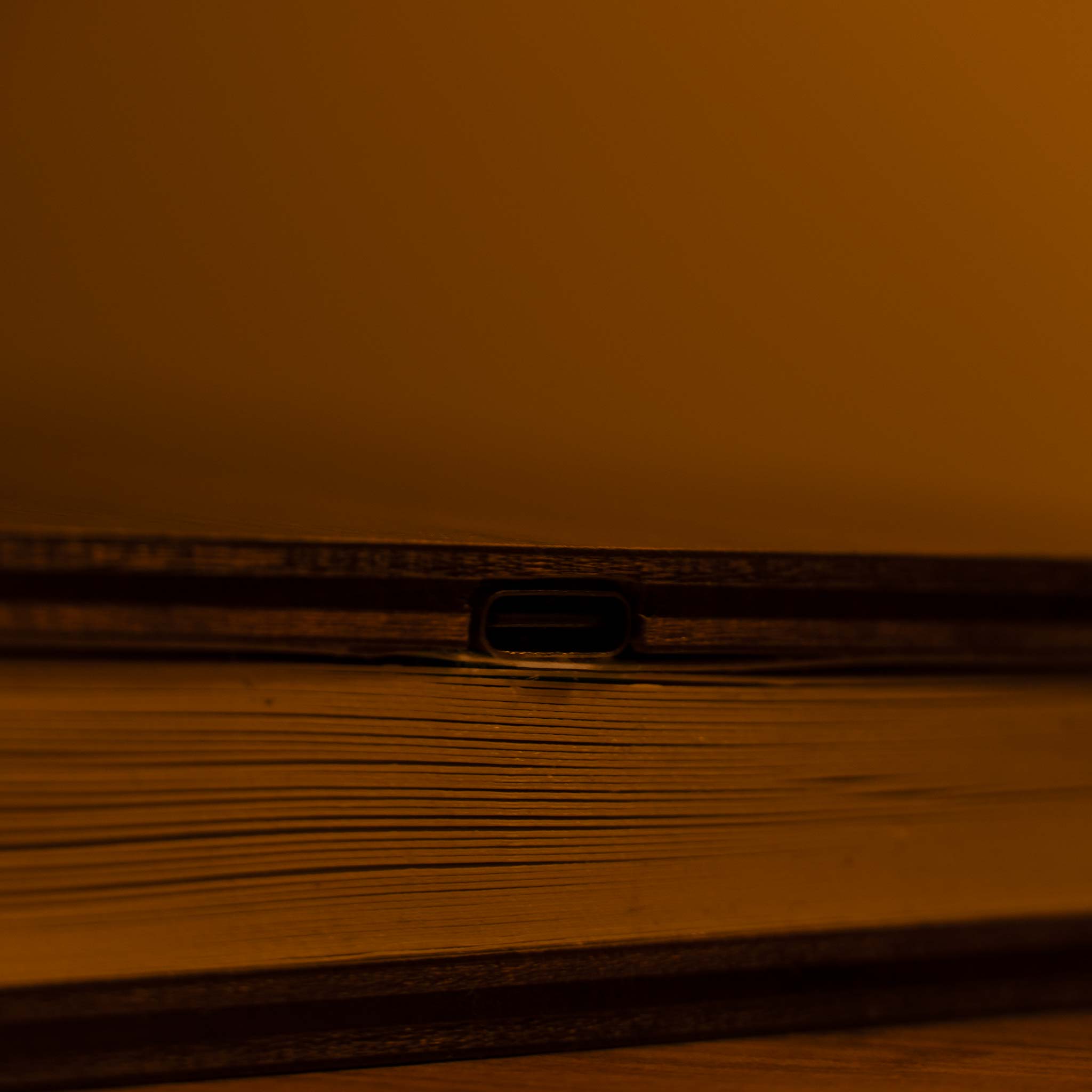 Silhouette of a car on a road at sunset with an orange sky