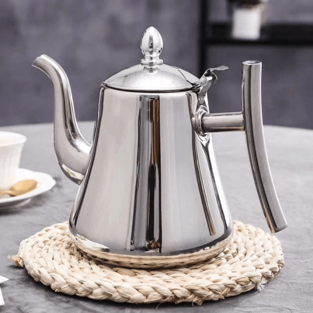 Silver teapot on a woven trivet with a blurred background