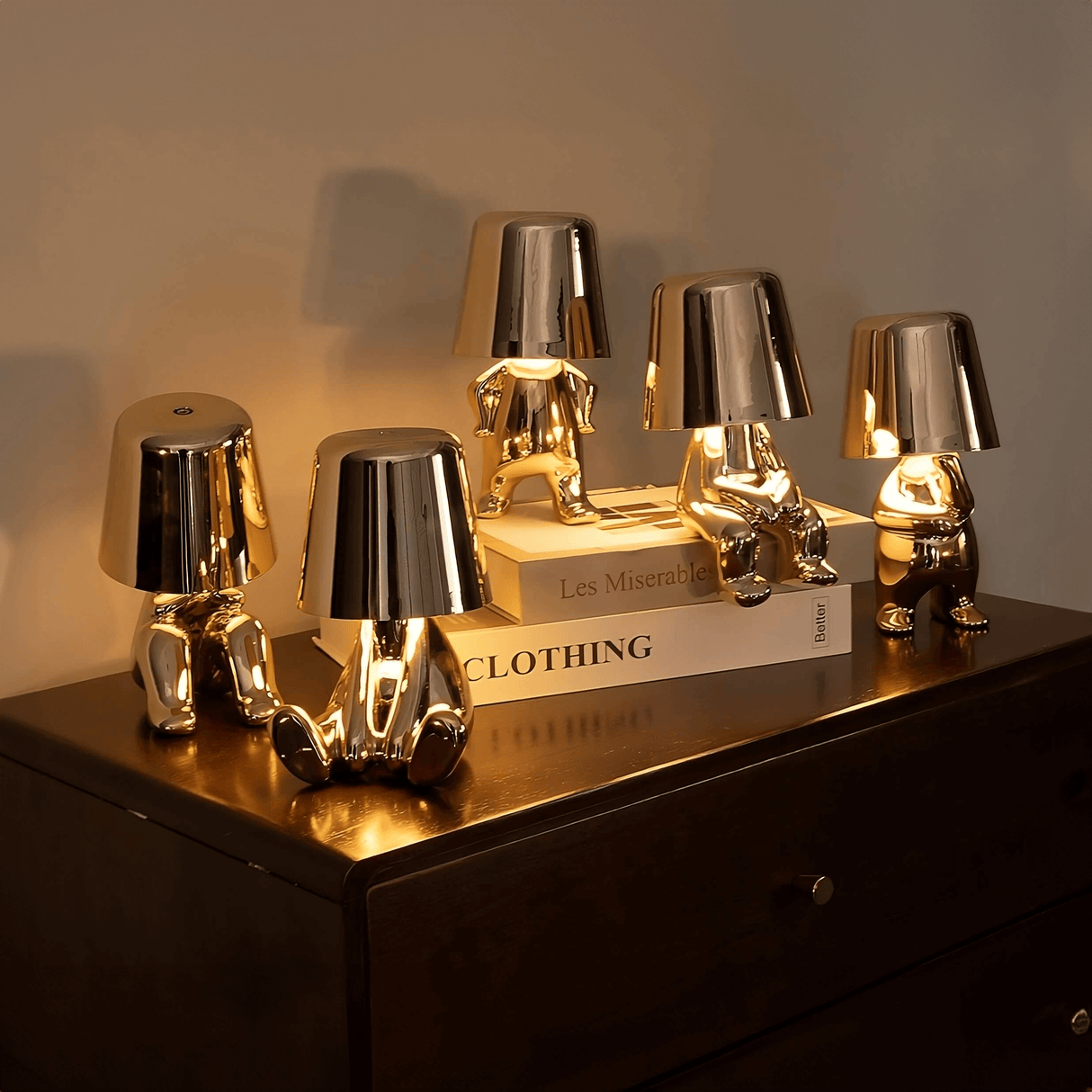 Set of gold and silver table lamps on a dark surface with a blurred background