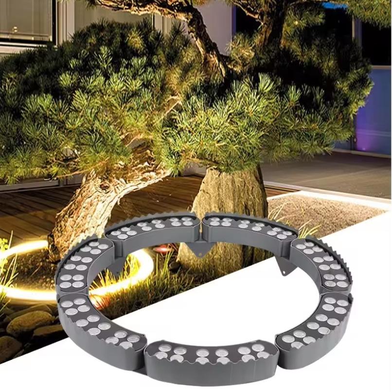 Circular garden light fixture on a garden path with trees and rocks in the background