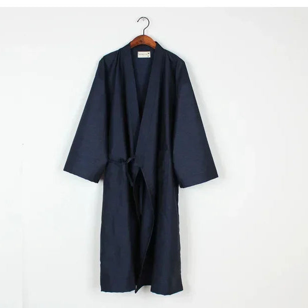 Navy blue robe on a hanger against a white background