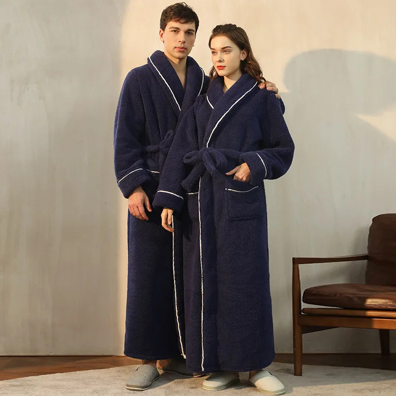 Two people wearing navy blue robes with white trim in a room.