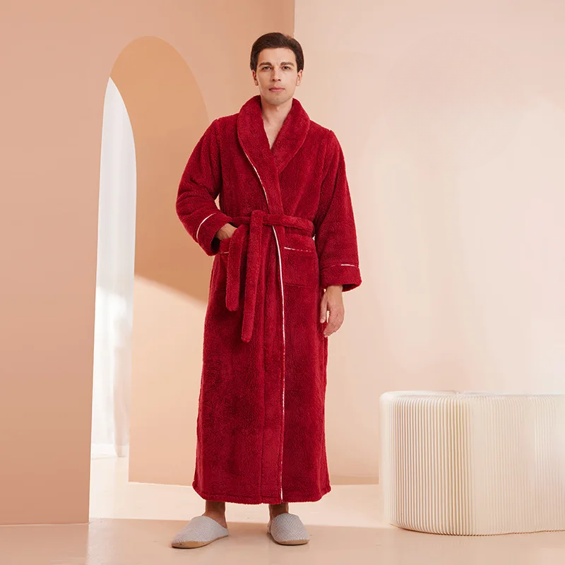 Man wearing a red robe in a minimalistic room with a beige and white color scheme.