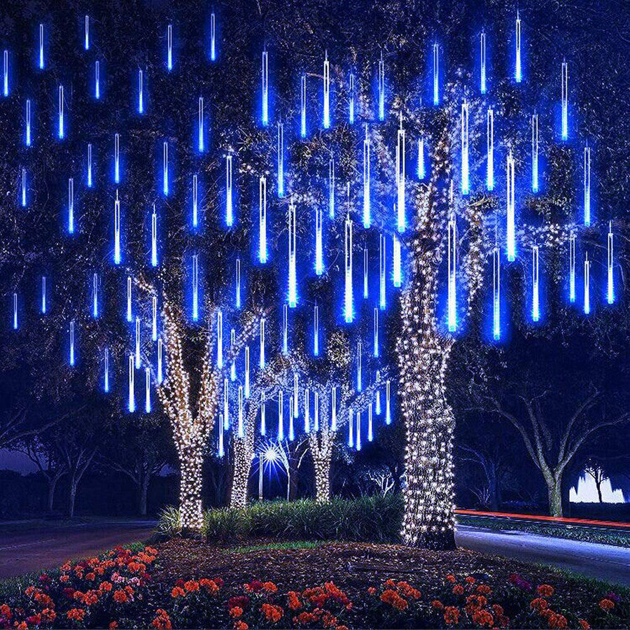 Decorative blue LED lights hanging from trees in a garden setting