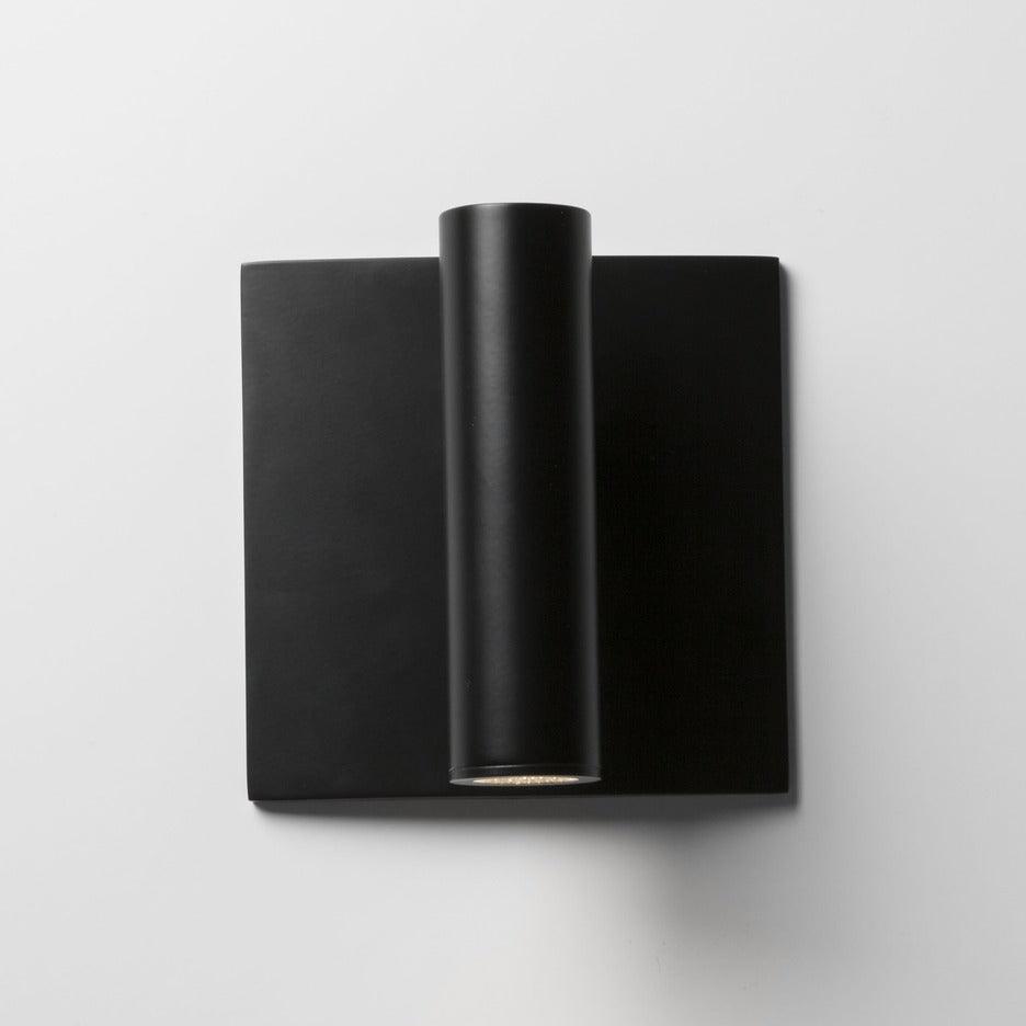 Black wall-mounted light fixture on a white background